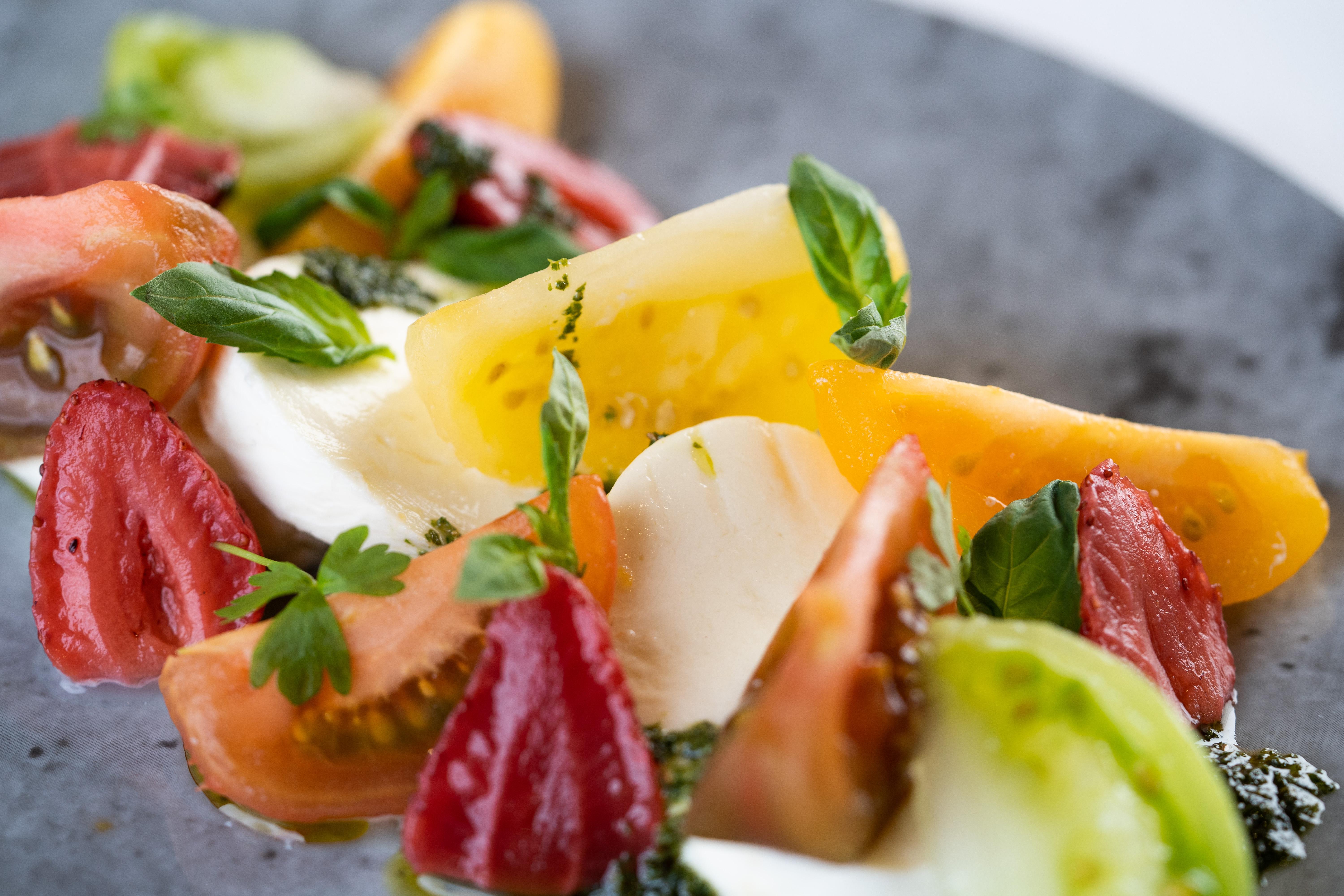 The Fitzwilliam Hotel Belfast Exterior foto The photo shows a vibrant salad featuring slices of various tomatoes, including red, yellow, and green varieties. The tomatoes are paired with fresh mozzarella cheese and garnished with basil leaves. The dish is presented on a round, dark plate, high